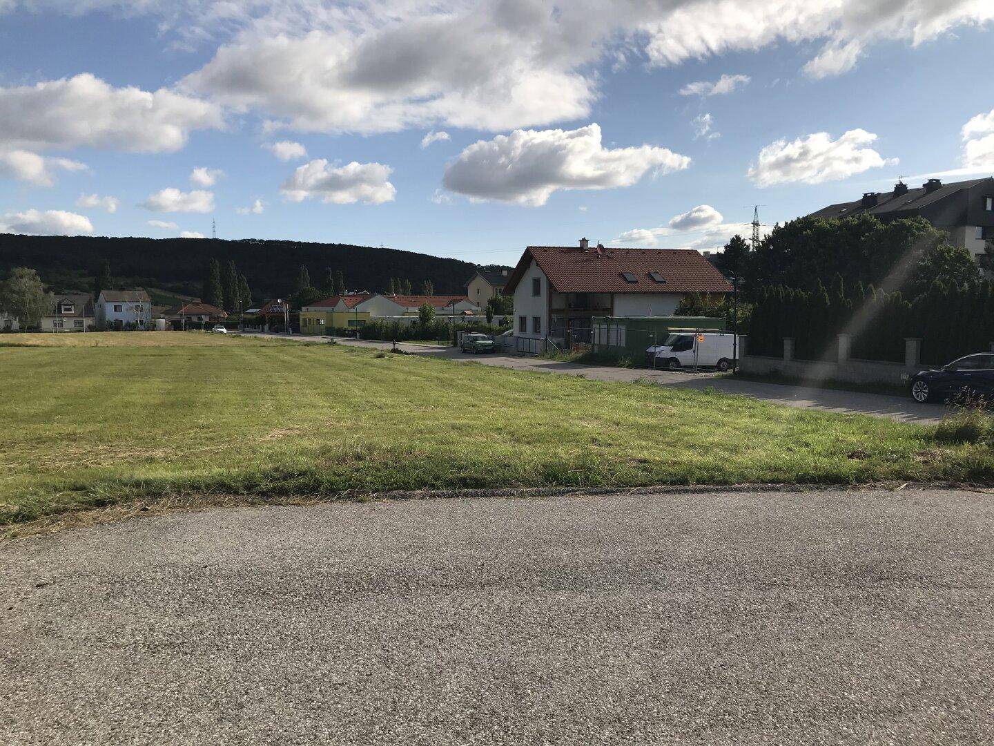 Großes, sonniges Baugrundstück mit weitem Blick auf die Nachbarschaft und grüne Landschaft.