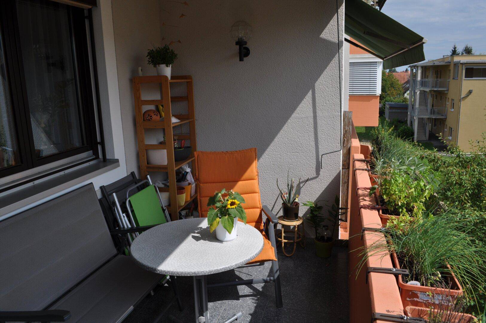 Gemütlicher Balkon mit Sitzgelegenheiten und Pflanzen, der zum Verweilen im Freien einlädt.