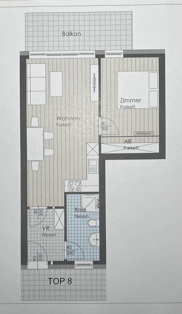 Grundriss einer Wohnung mit Wohnbereich, Schlafzimmer, Bad und Balkon.