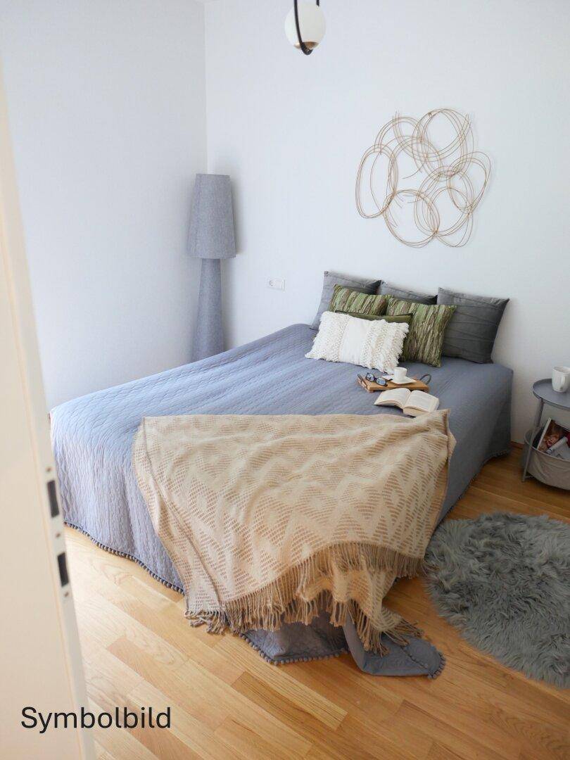Schlafzimmer mit Doppelbett, Holzboden und moderner Dekoration in hellen Farben.