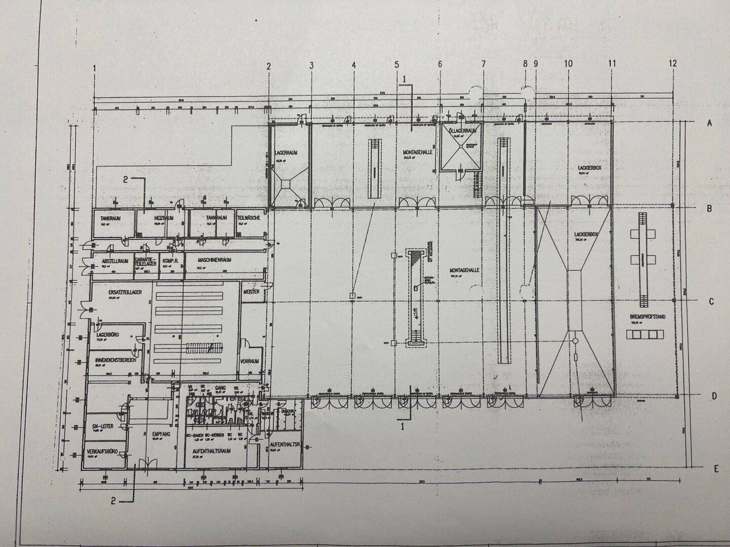 Detaillierter Grundriss des Gewerbegebäudes mit verschiedenen Werkstatt-, Lager- und Bürobereichen.