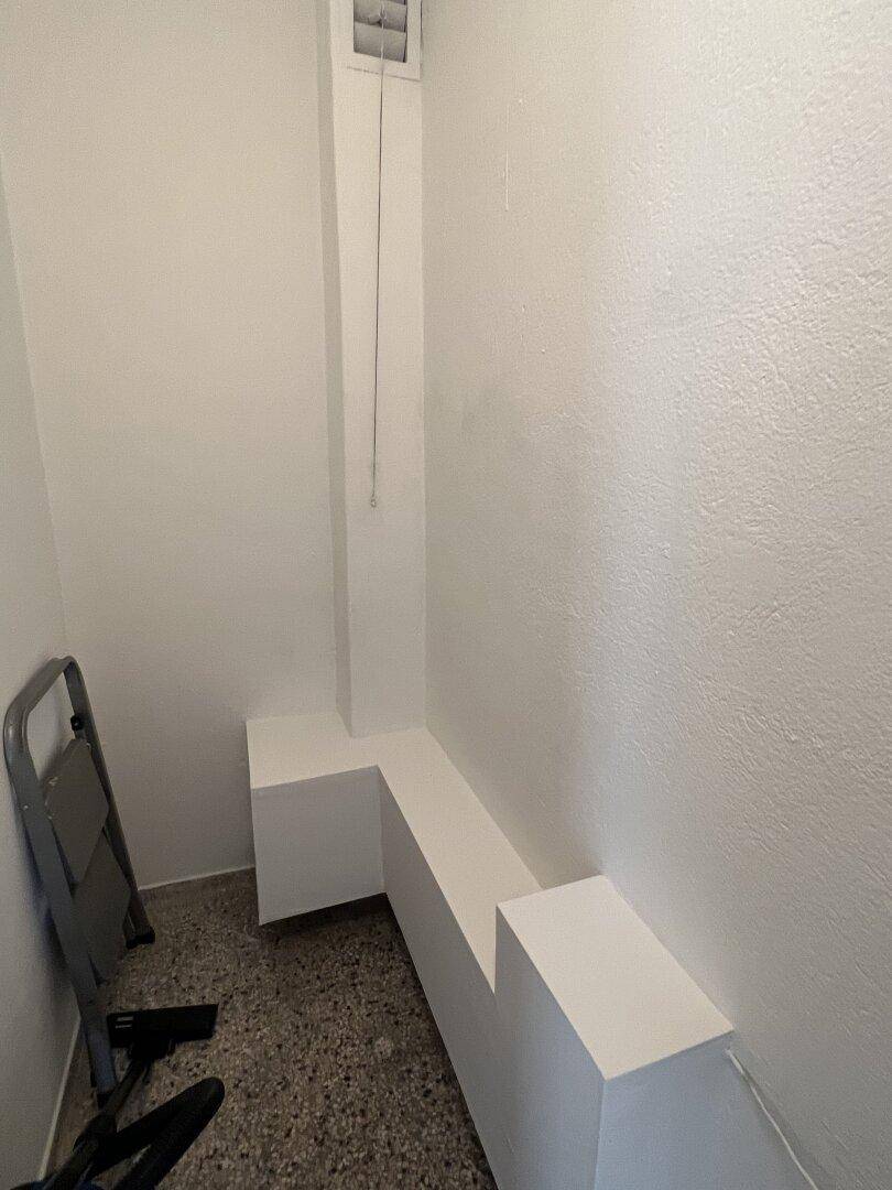 Praktischer Abstellraum mit weiß gestrichenen Wänden und robustem Bodenbelag.