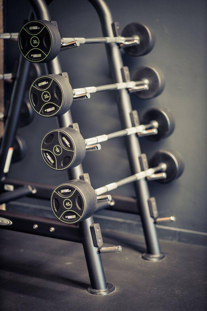 Nahaufnahme eines Hantelständers mit verschiedenen Gewichtsscheiben in einem Fitnessstudio.