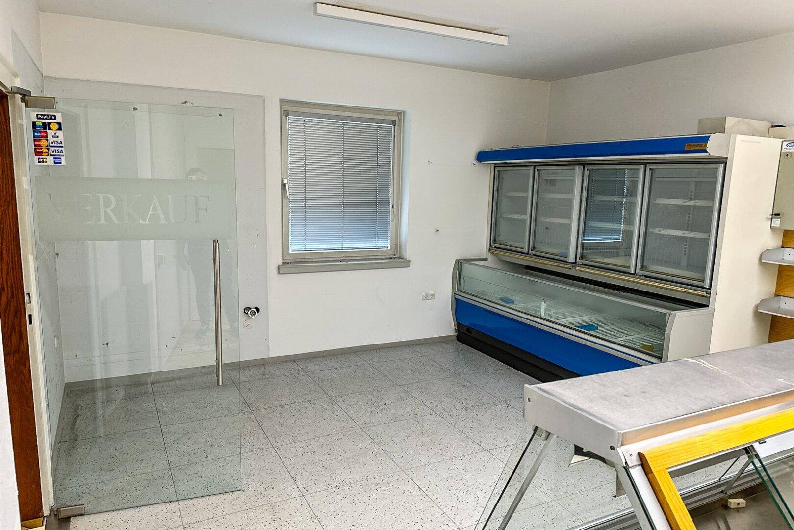 Verkaufsraum mit Glastür, Fenster und gewerblichen Kühlgeräten, ausgestattet für den Einzelhandel.