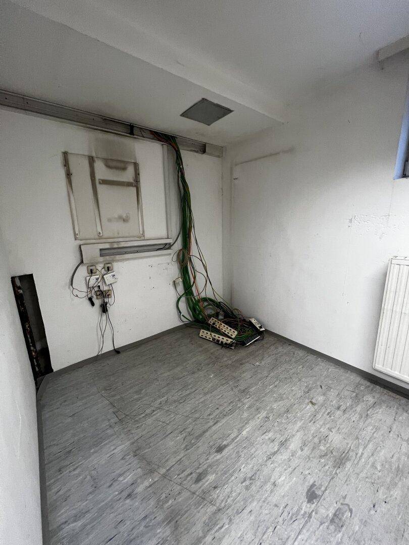 Kleiner Abstellraum mit freiliegenden Kabeln und einem Fenster, ideal für Technik.