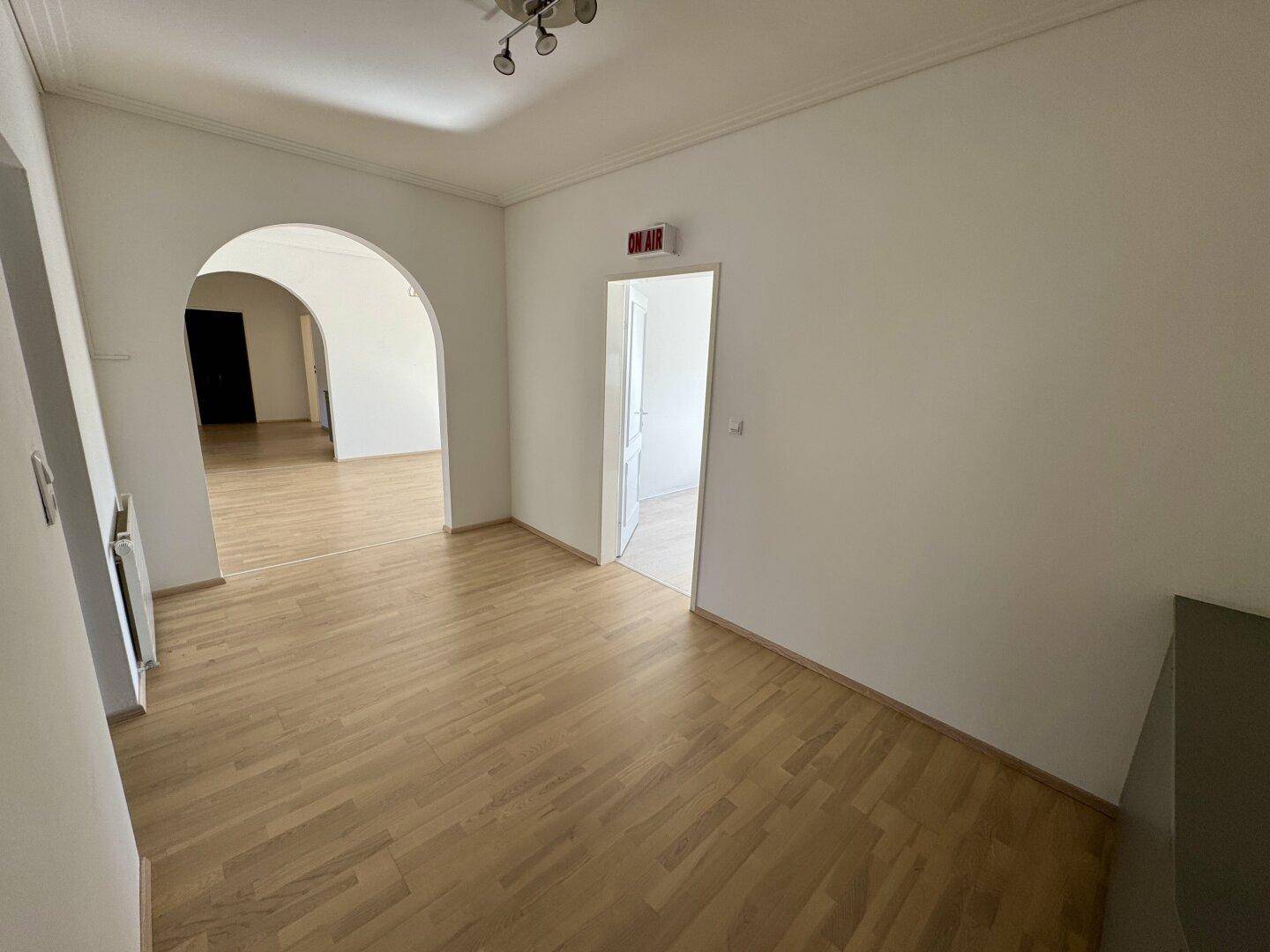 Heller Flur mit Parkettboden und einem Durchgang zu anderen Bereichen der Wohnung.