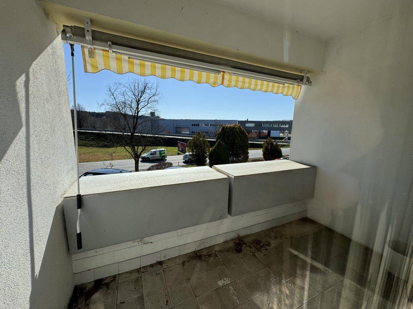 Balkon mit Markise und Blick auf die Umgebung, ideal für entspannte Stunden im Freien.