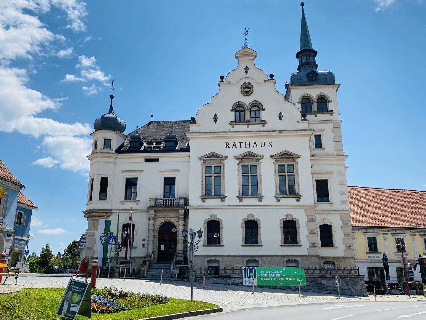 Historisches Rathaus mit markanter Architektur und einem Turm unter blauem Himmel.