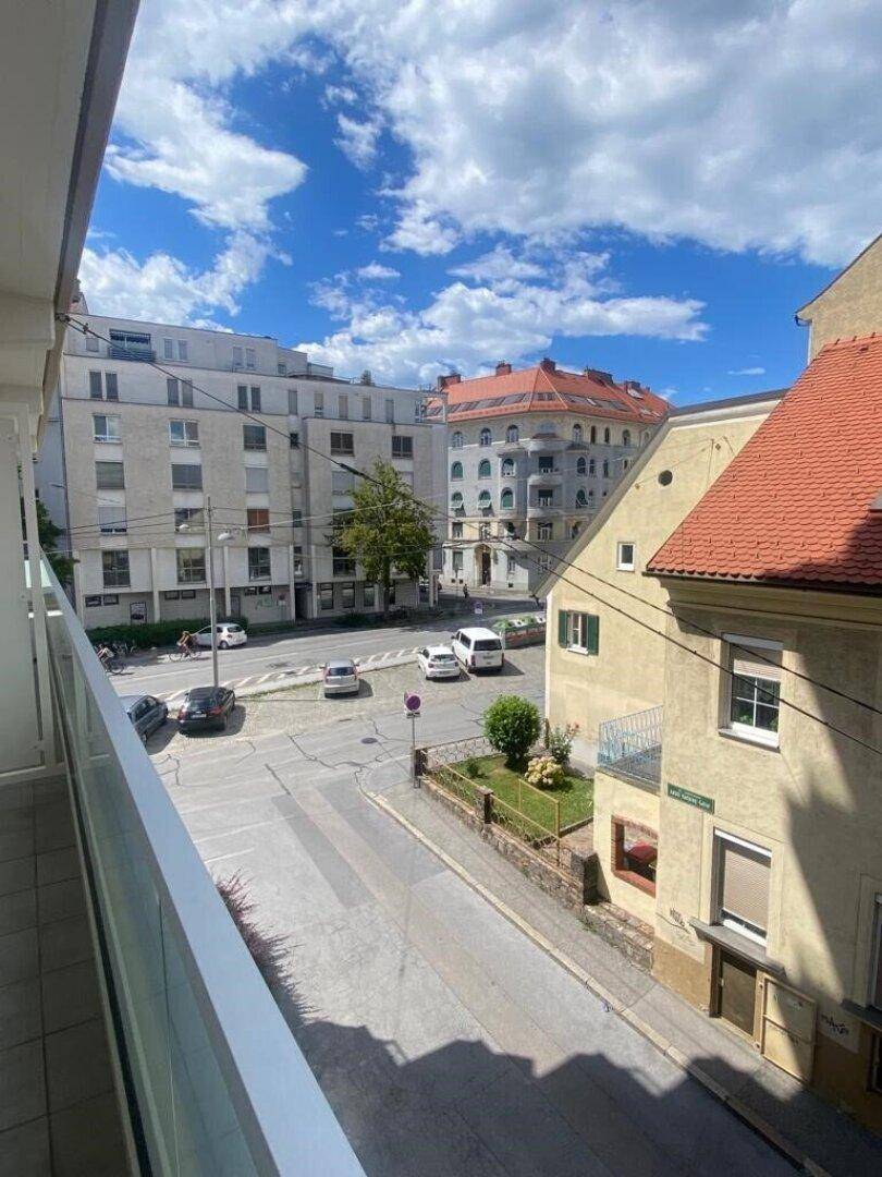 Balkon mit Blick auf die belebte Straße und die umliegenden Stadtgebäude.
