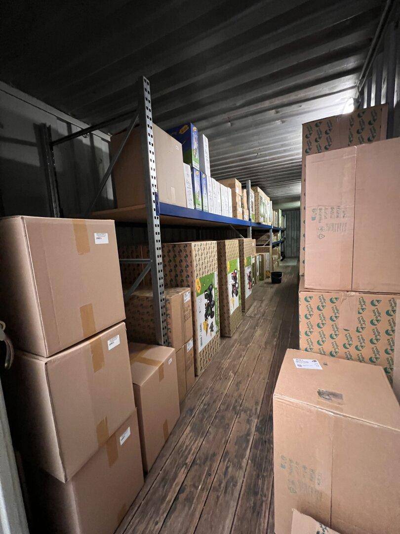 Langer, schmaler Lagercontainer gefüllt mit Kartons auf Regalen, optimiert für Stauraum.