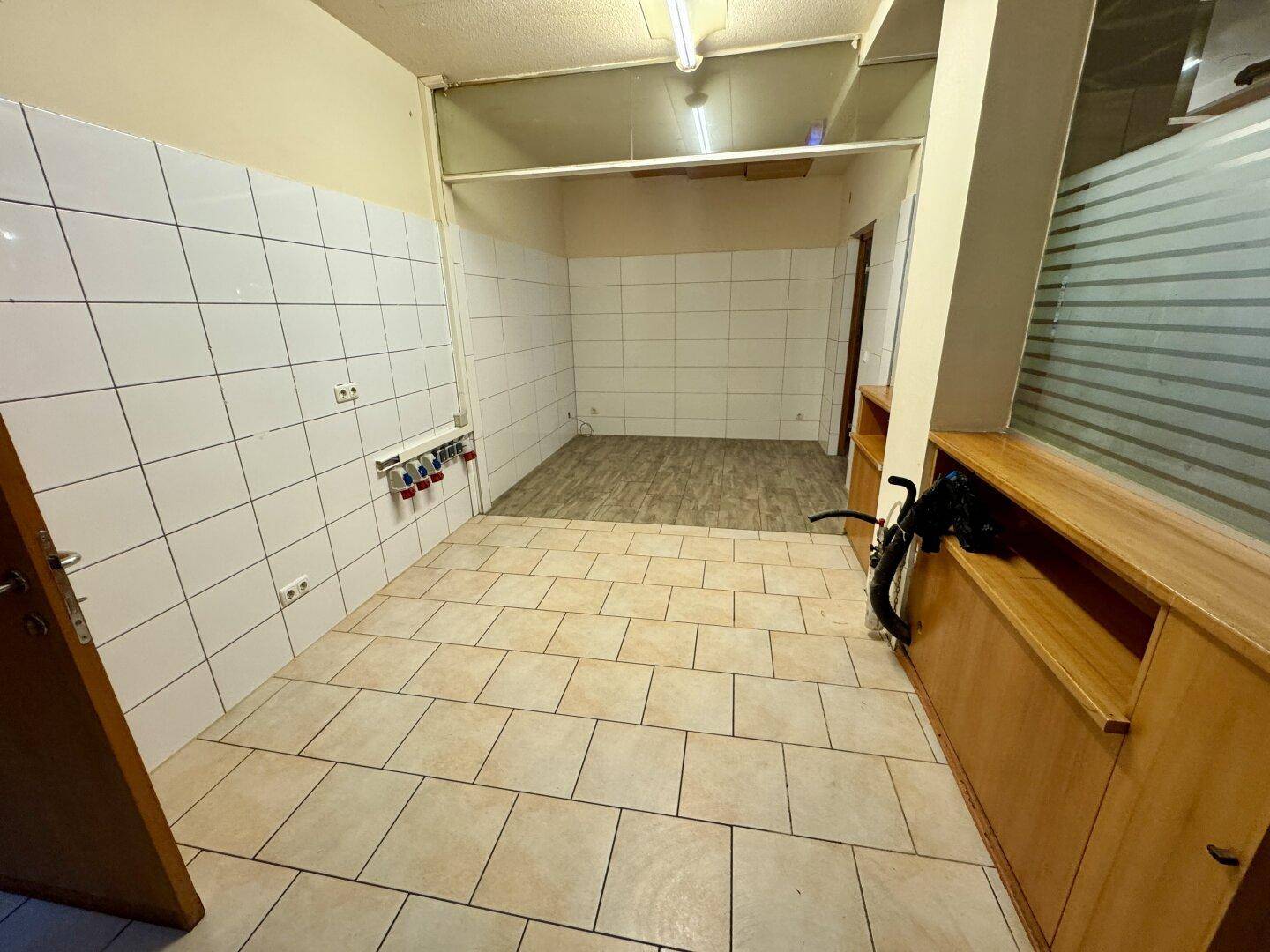 Eine geflieste Küche mit weißen Wandfliesen und Anschlüssen für Geräte, bereit zur Installation.