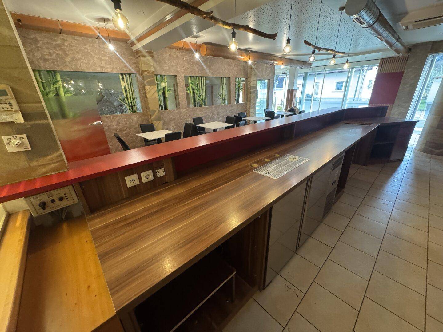 Die lange Bar mit Holzoberflächen und integrierten Kühlgeräten, bereit für den Betrieb.