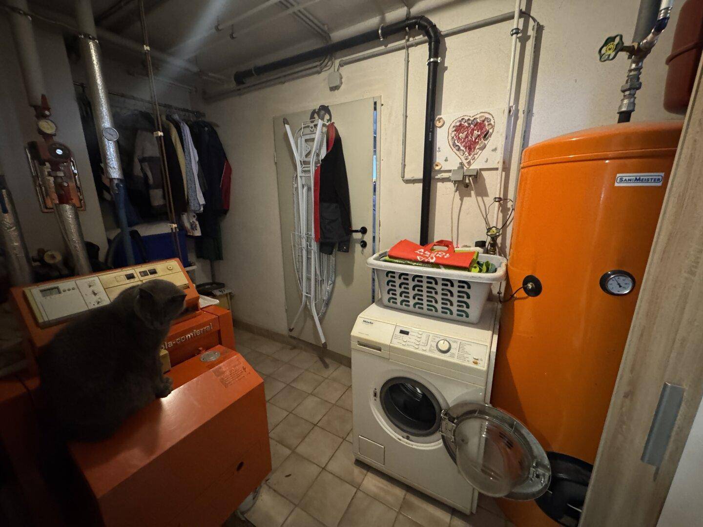 Hauswirtschaftsraum mit Heizungsanlage, Waschmaschine und Warmwasserspeicher.