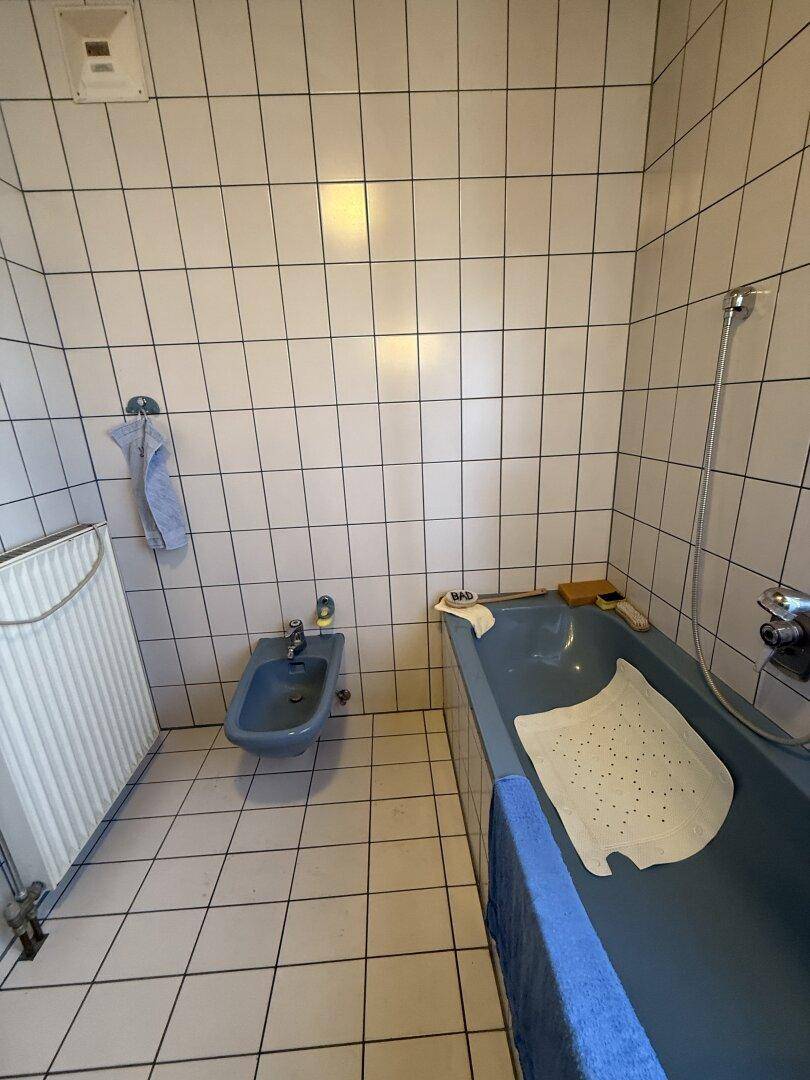 Badezimmer mit Badewanne, Bidet und weißen Fliesen, bietet Komfort und Funktionalität.