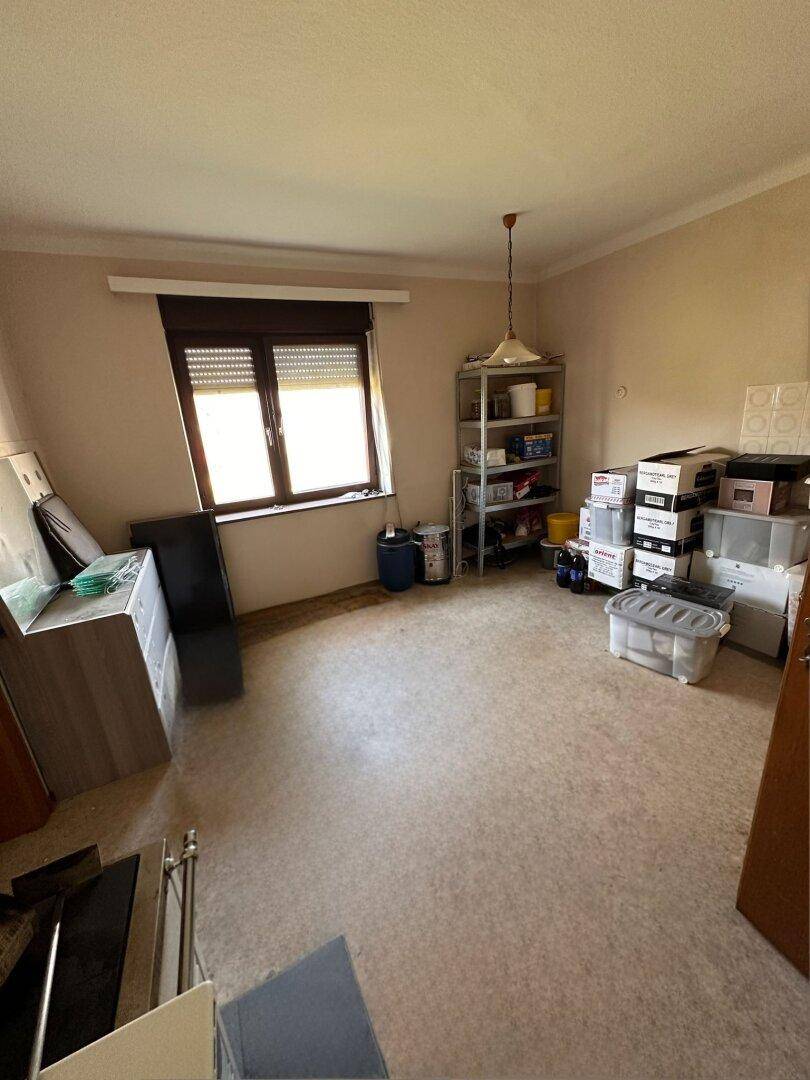Abstellraum mit Regalen und Kartons, mit Fenster für natürliches Licht.