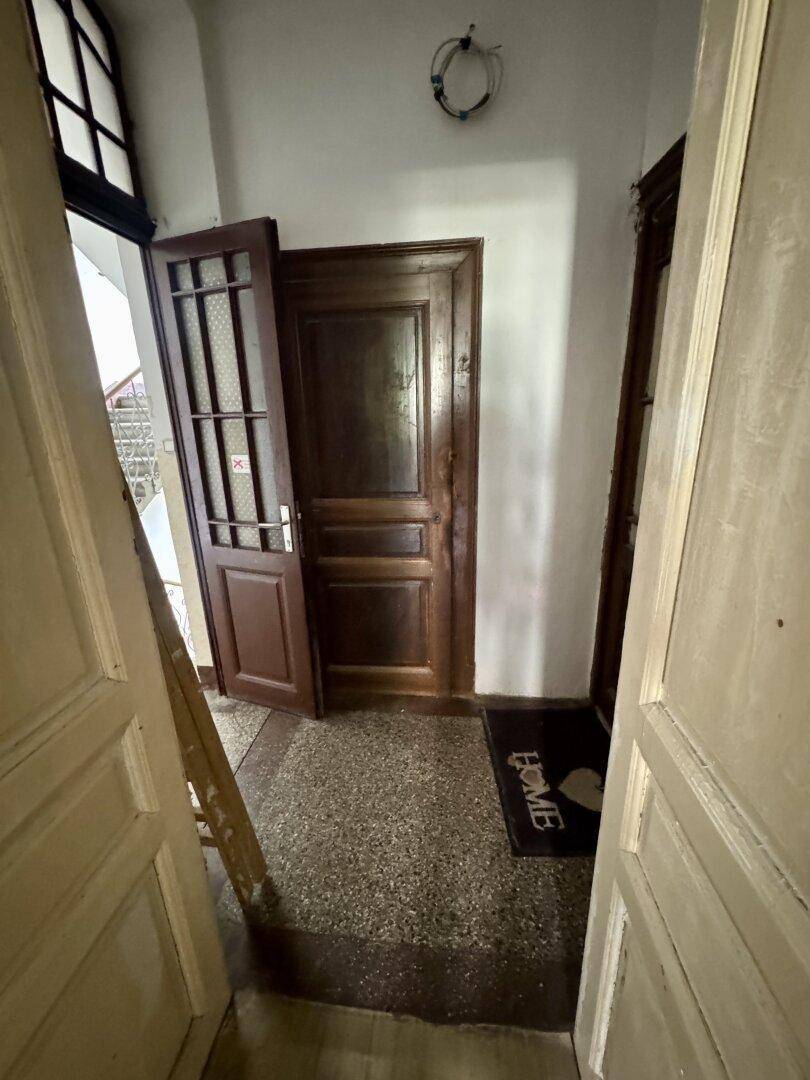 Eingangsbereich mit zwei Holztüren und einem Teppich, der ein Gefühl von Zuhause vermittelt.