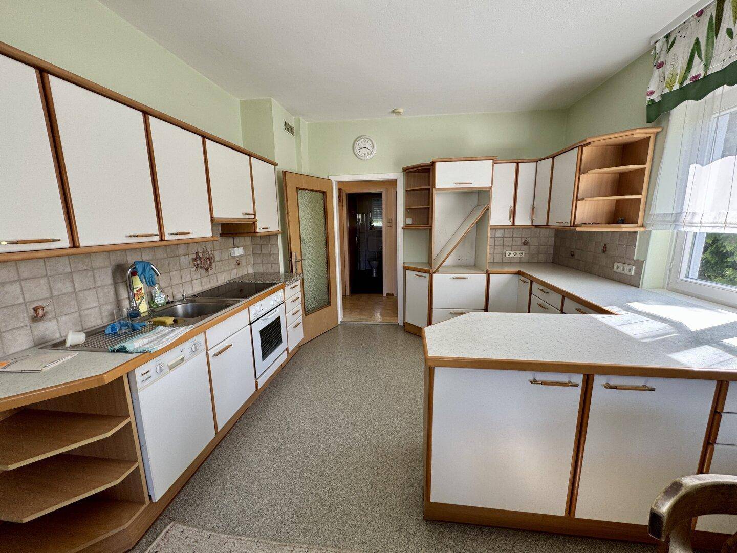 Geräumige Küche im traditionellen Stil mit vielen Schränken, Fliesenboden und Geräten.