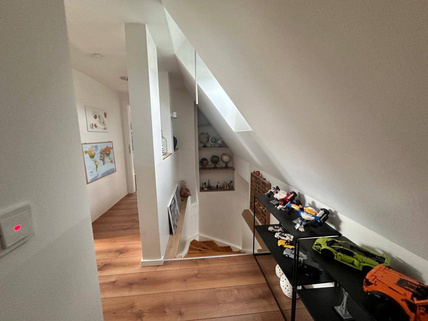 Heller Flur im Dachgeschoss mit Dachschräge und Holzboden.