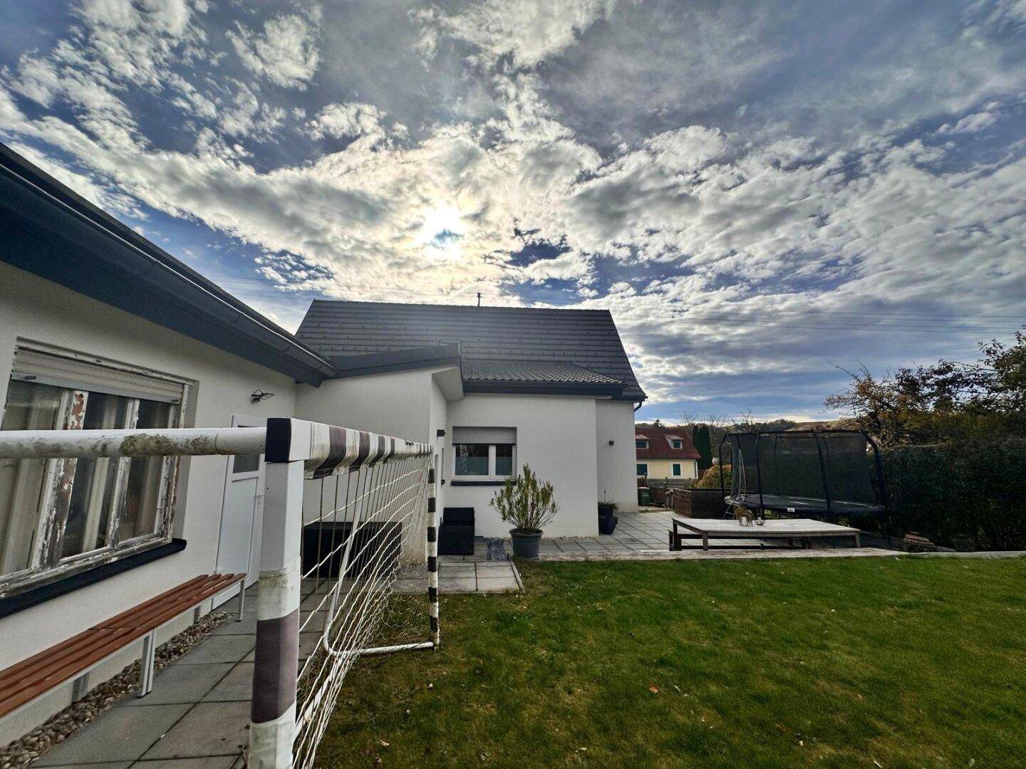 Seitenansicht des Hauses mit großem Garten, Trampolin und Fußballtor.