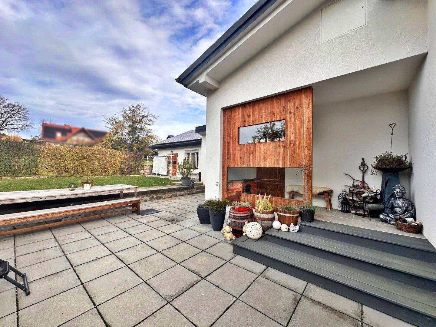 Attraktive Terrasse mit Holzelementen an der Fassade und dekorativen Pflanzen.