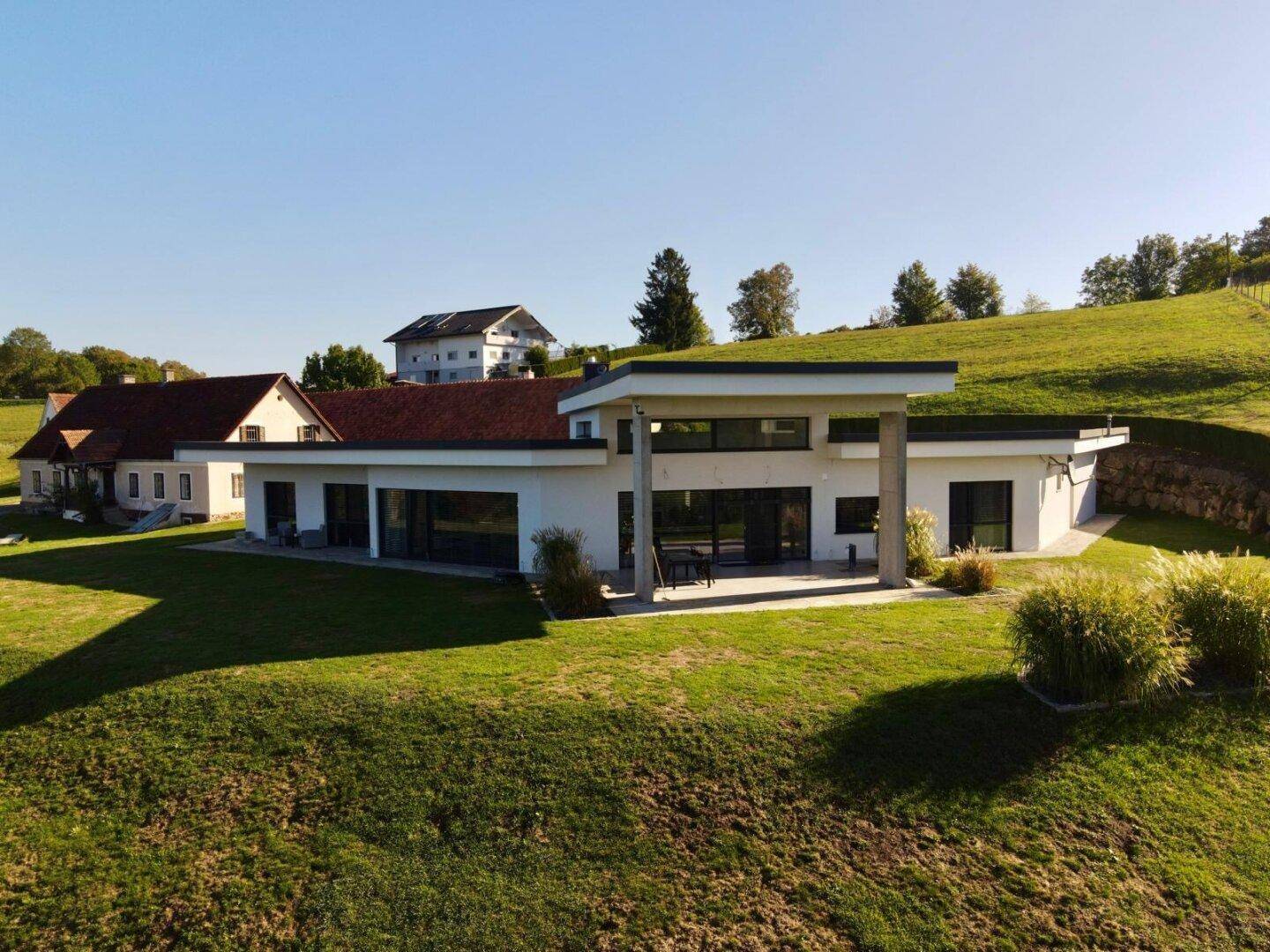 Moderne Architektur des Hauptgebäudes mit großen Fensterfronten und weitem Blick ins Grüne.
