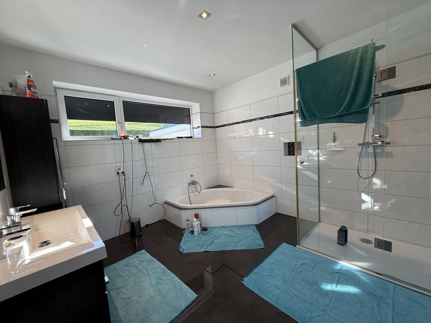 Geräumiges Badezimmer mit Eckbadewanne, separater Dusche und Fenster.