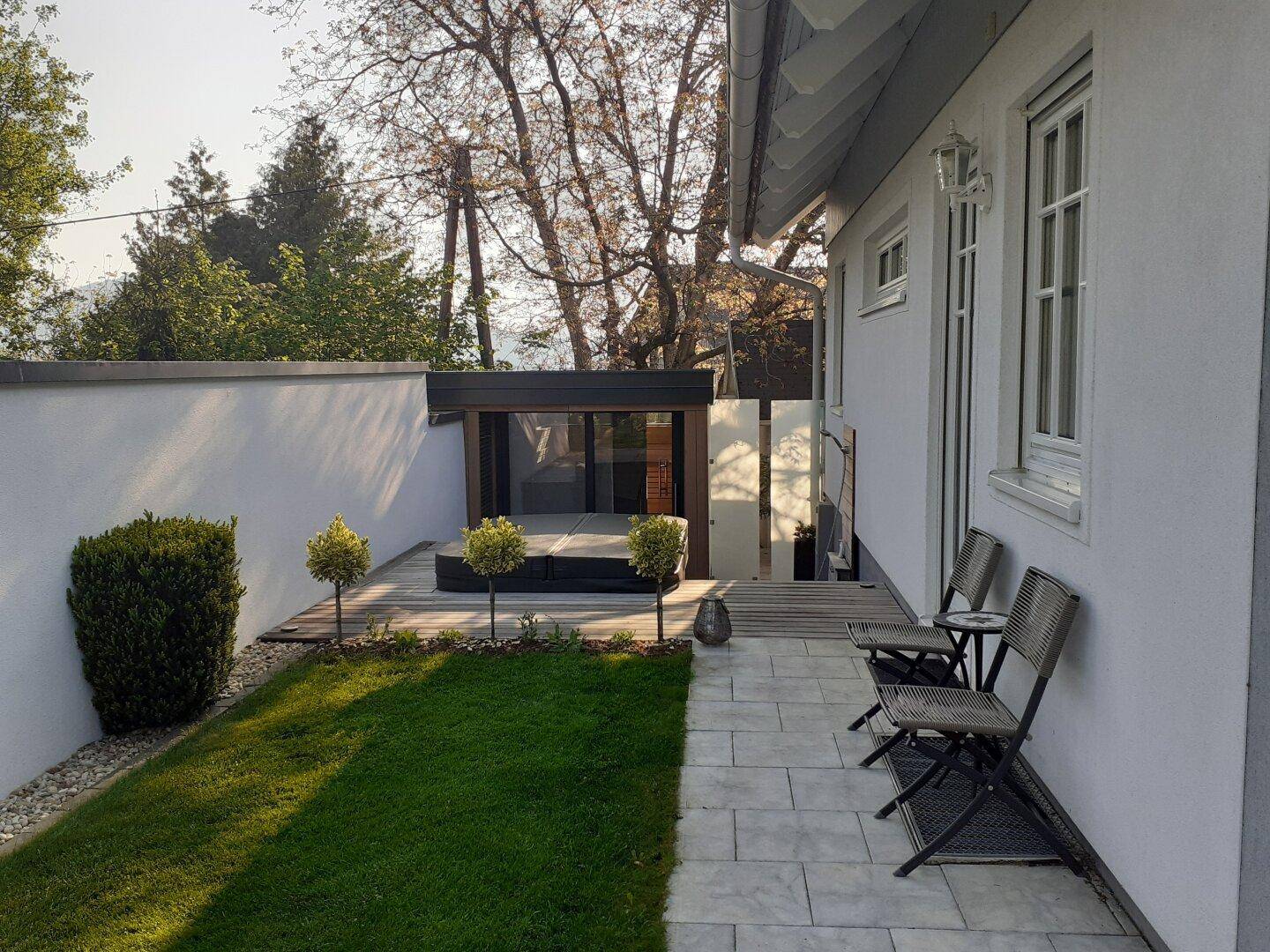 Kleine Terrasse mit Sitzgelegenheiten und einem modernen Whirlpool-Bereich im Freien.