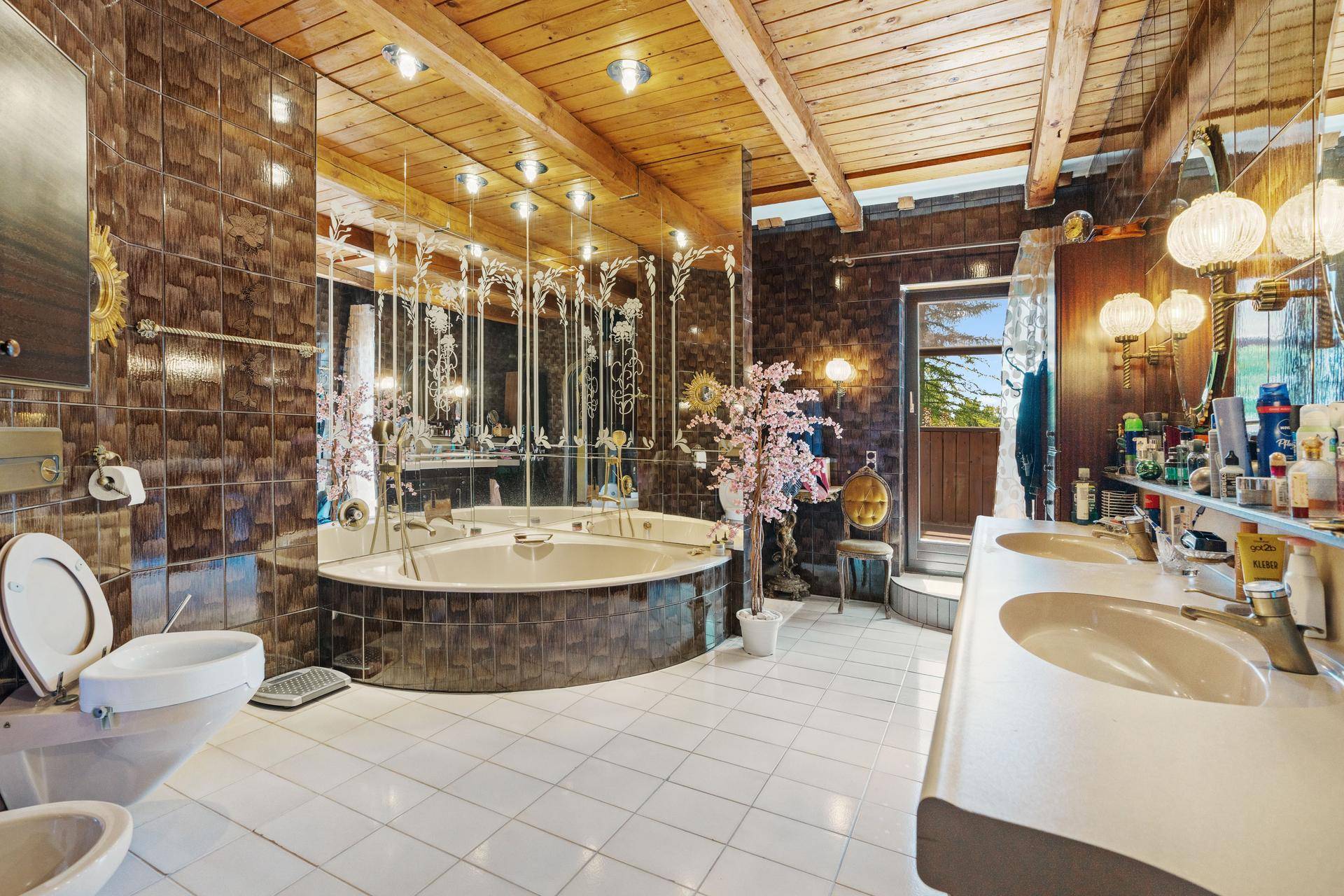 Luxuriöses Badezimmer mit großer Eckbadewanne, Doppelwaschbecken und Holzdecke.