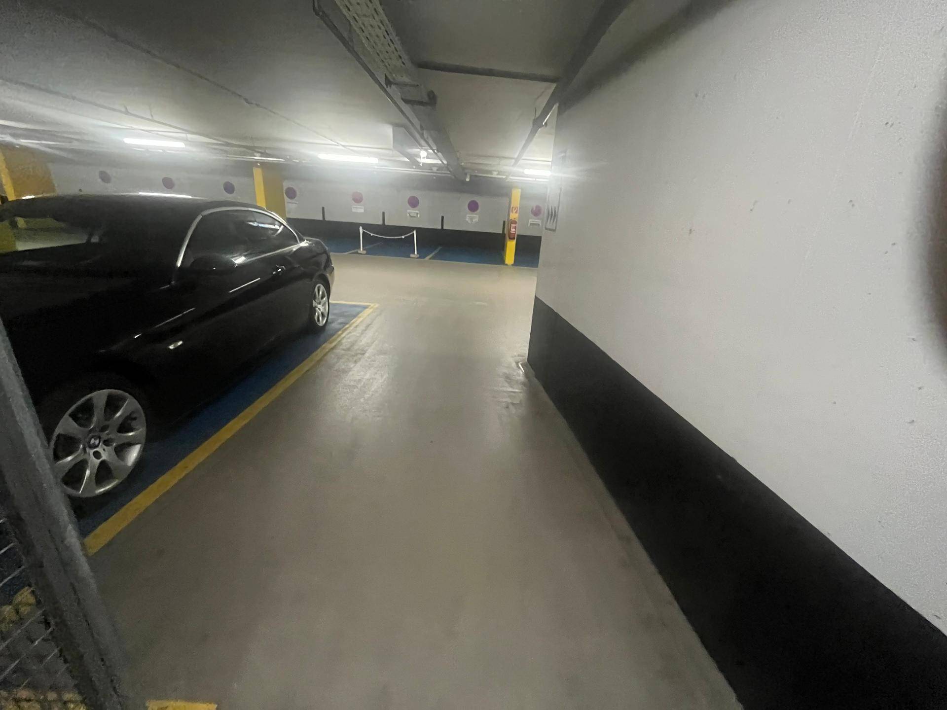 Tiefgarage mit einem geparkten schwarzen Auto und ausreichend Stellplätzen.