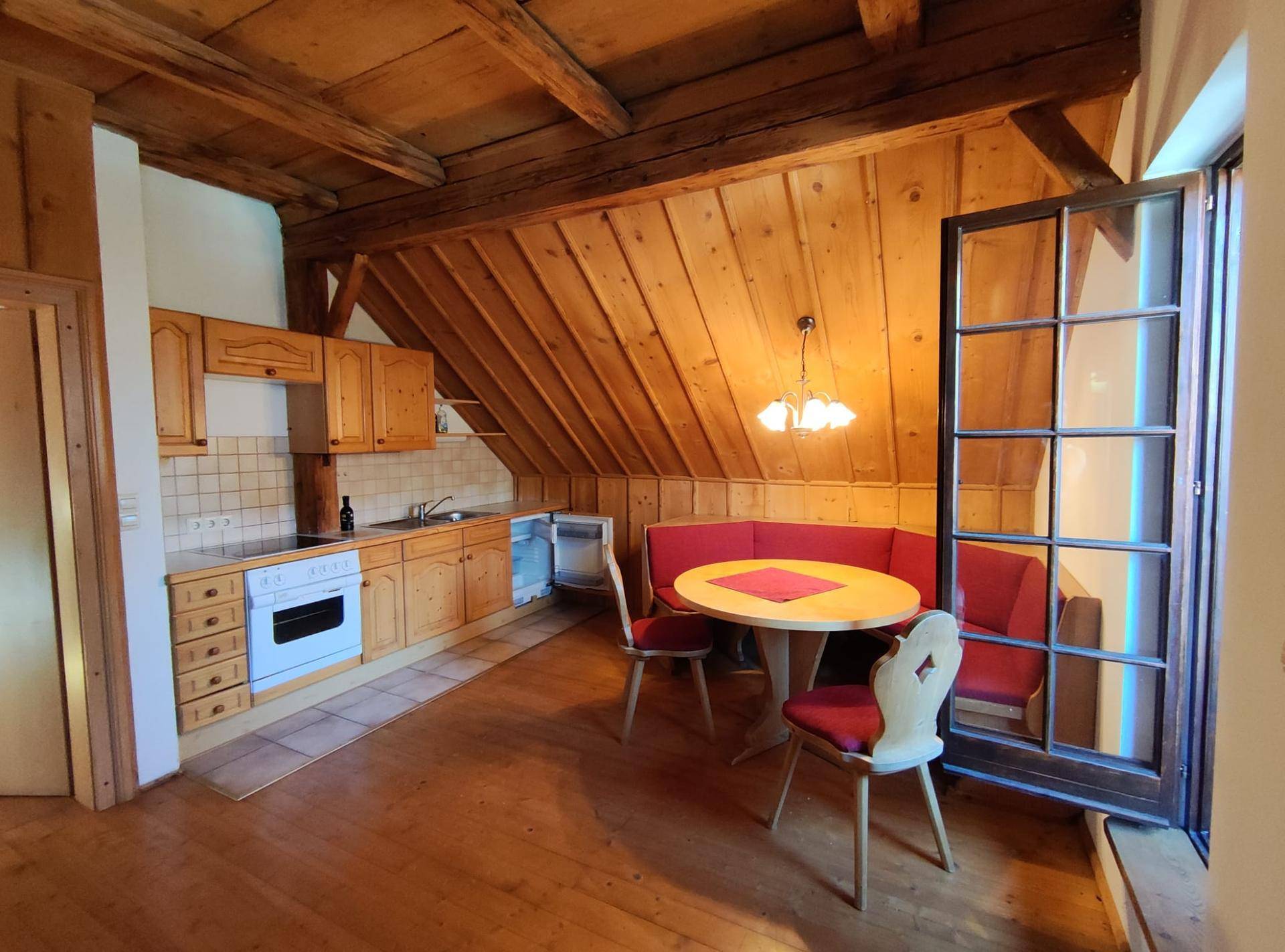 Traditionelle Holzküche mit Einbaugeräten und gemütlicher Essecke, ideal für gemeinsame Mahlzeiten.