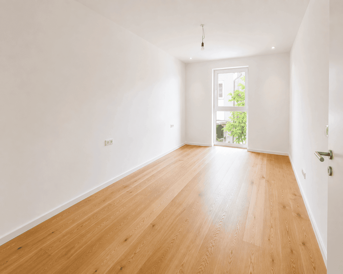 Helles Zimmer mit Holzboden und Fenster, ideal als Schlafzimmer oder Büro nutzbar.