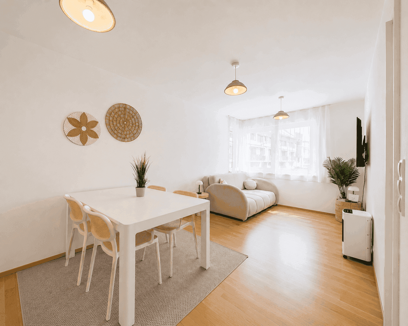 Geräumiger Wohn-Essbereich mit Holzboden, modernem Sofa und Esstisch für gesellige Stunden.