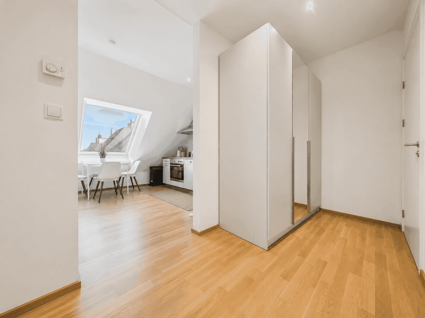 Heller Flur mit großem Einbauschrank und Zugang zum offenen Wohnbereich.