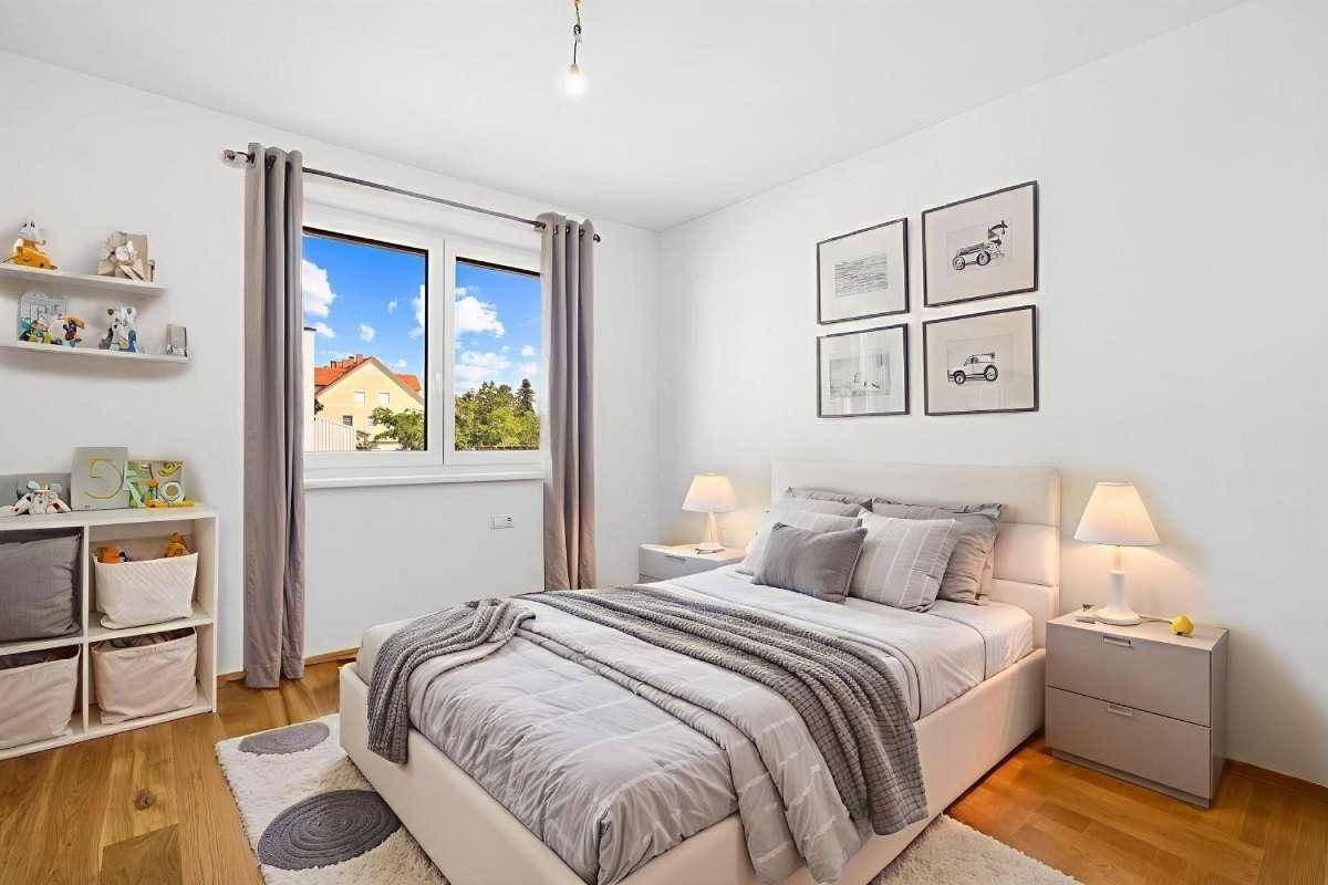 Helles Schlafzimmer mit Holzboden, großem Fenster und moderner Einrichtung.