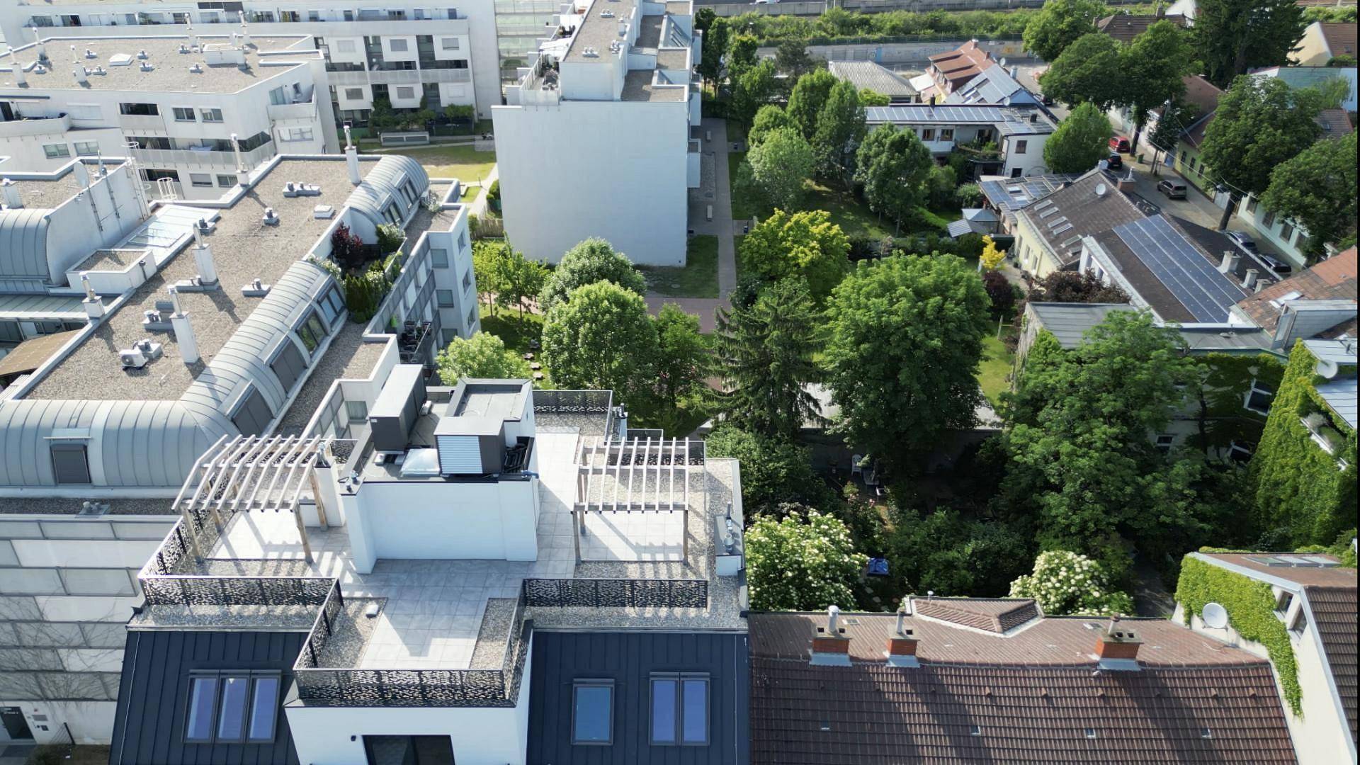 Weitläufige Luftaufnahme des Gebäudes und der umliegenden Wohngegend mit viel Grün.