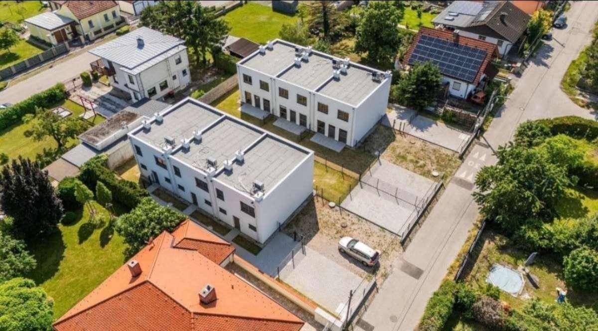 Luftaufnahme von modernen Reihenhäusern mit Flachdächern in einer Wohnsiedlung.