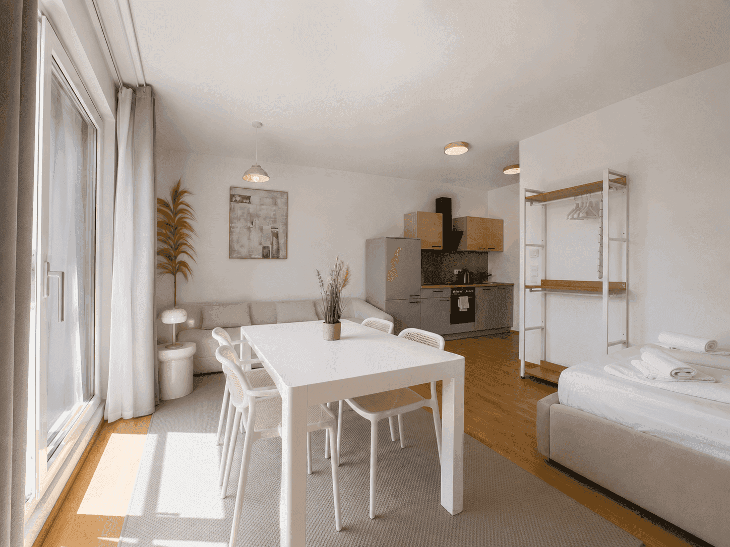Lichtdurchflutetes Studio-Apartment mit moderner Küche, Essbereich und gemütlichem Schlafbereich.