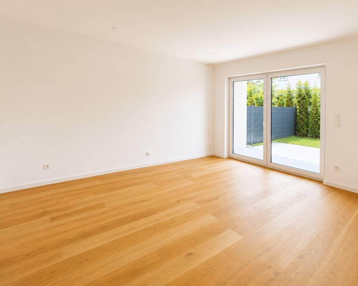 Geräumiges Wohnzimmer mit hellem Parkettboden und großer Schiebetür zum privaten Gartenbereich.