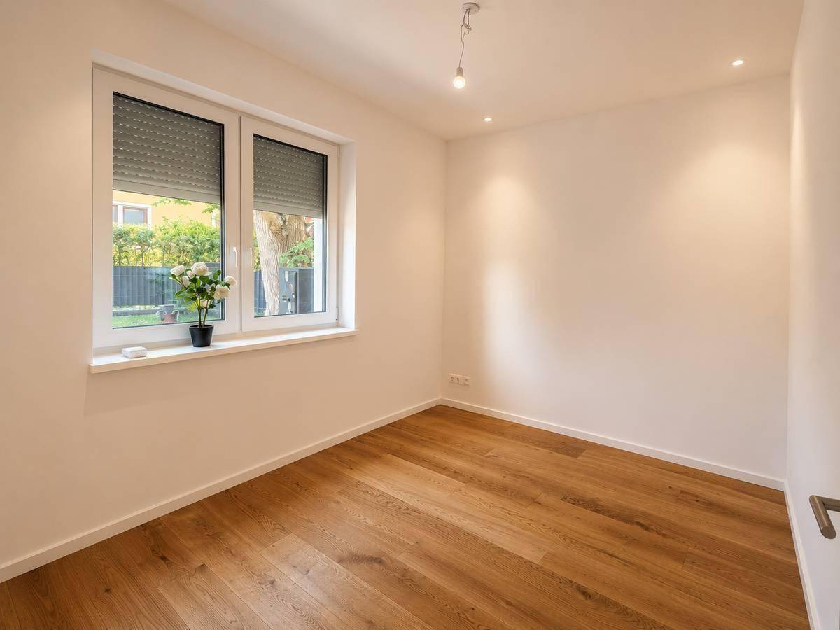 Helles Zimmer mit Parkettboden und Fenster mit Rollladen, ideal als Schlaf- oder Arbeitszimmer.