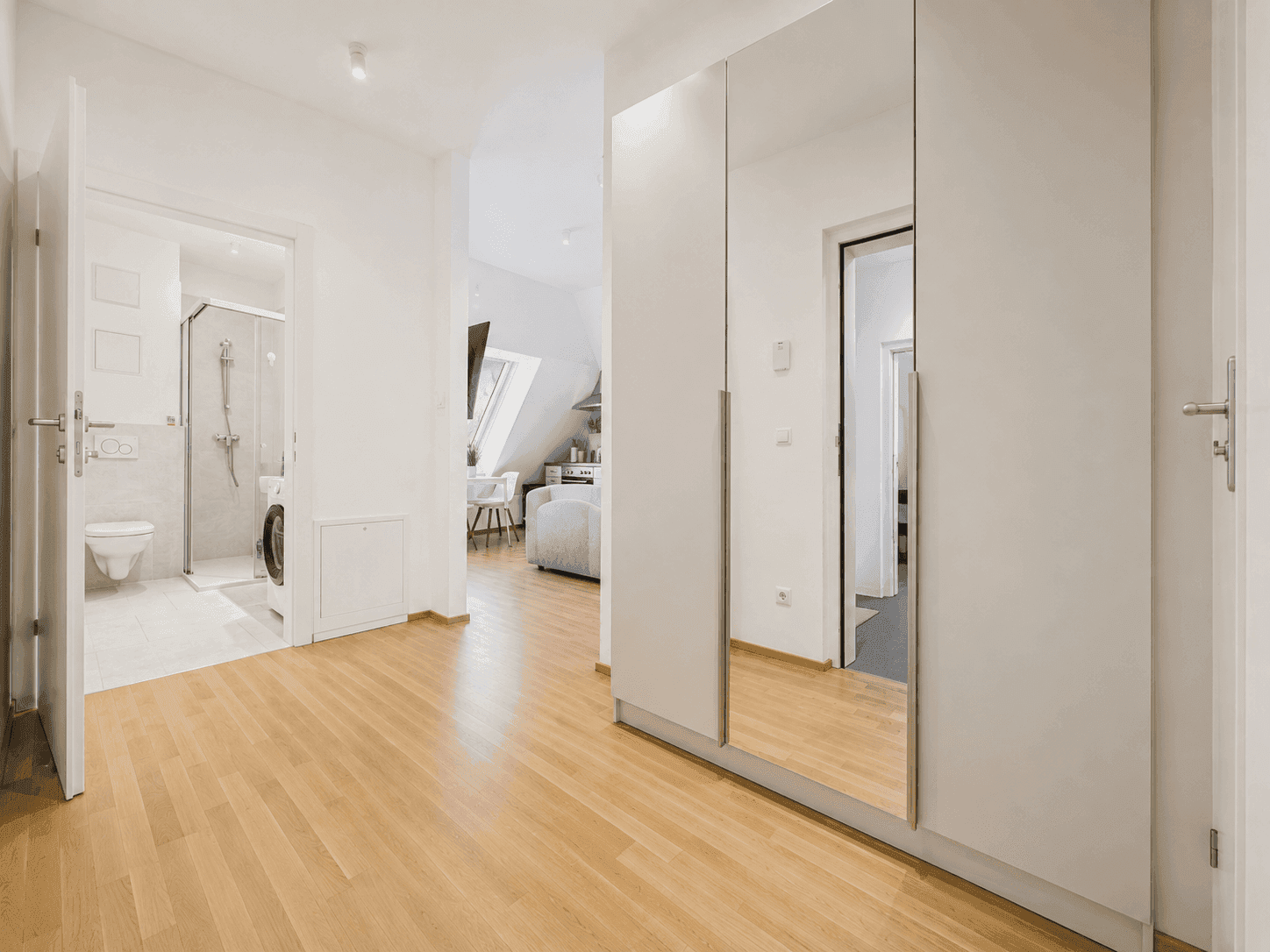 Geräumiger Flur mit Spiegelschrank und direktem Zugang zum modernen Badezimmer.