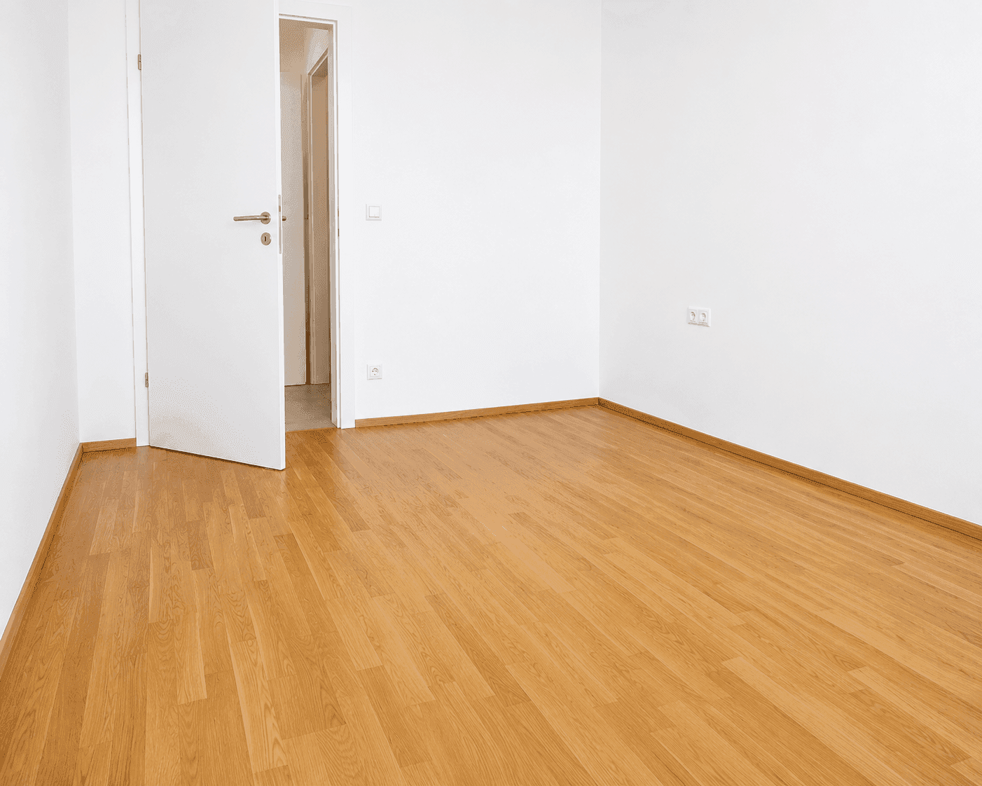 Helles Zimmer mit Holzboden und weiß gestrichenen Wänden, bereit zur individuellen Gestaltung.