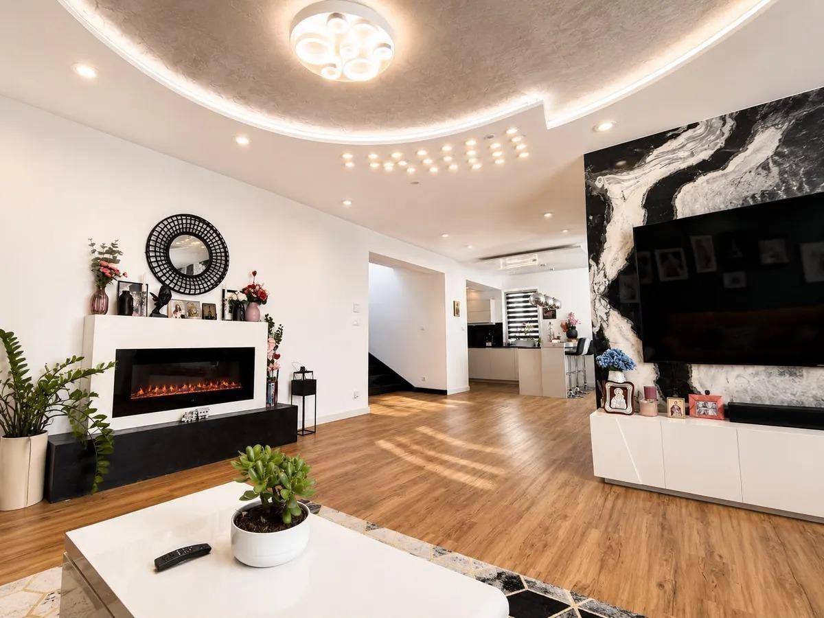 Modernes Wohnzimmer mit Kamin, Laminatboden und stilvoller Deckenbeleuchtung.