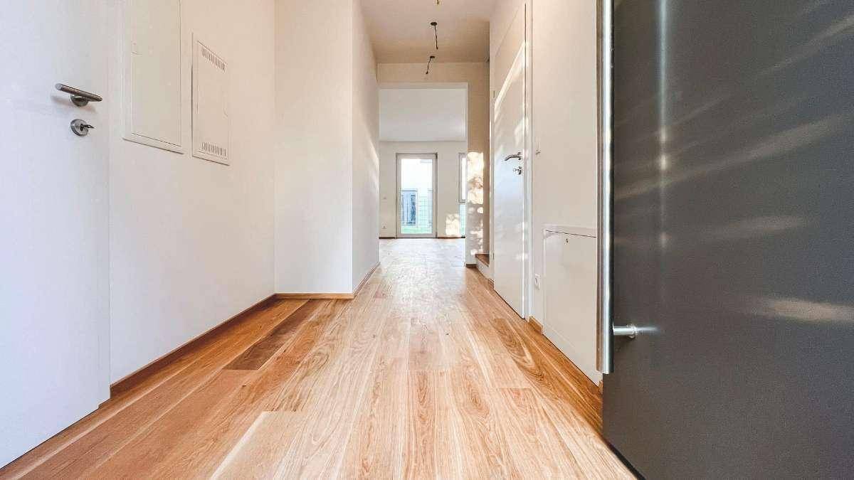 Langer, heller Flur mit Eichenparkett, der zu den verschiedenen Räumen führt.