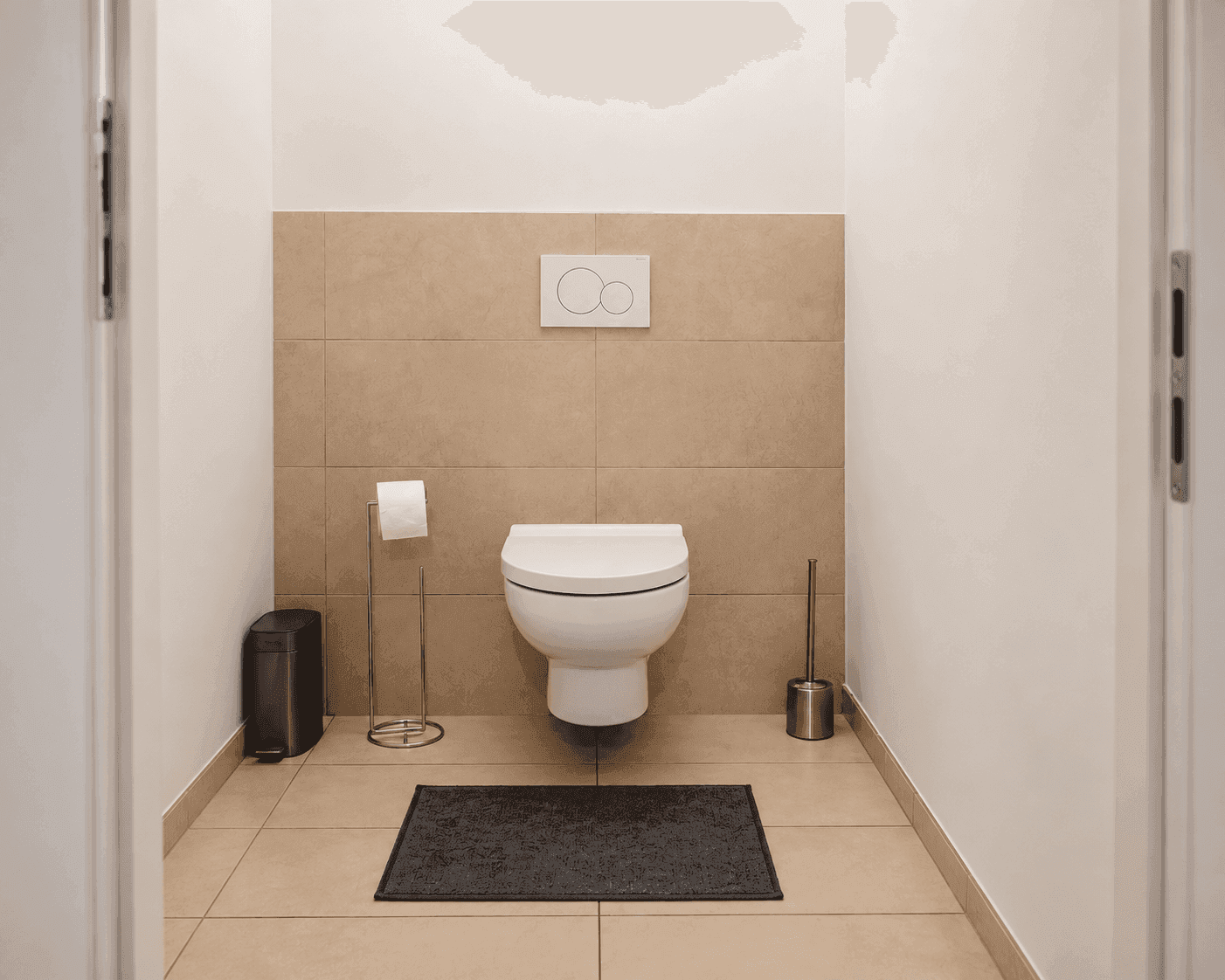Separate Gästetoilette mit Wand-WC und hellen Fliesen, funktional und sauber gestaltet.