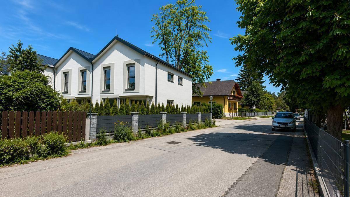 Ruhige Wohnstraße mit modernen Reihenhäusern und viel Grün in der Umgebung.