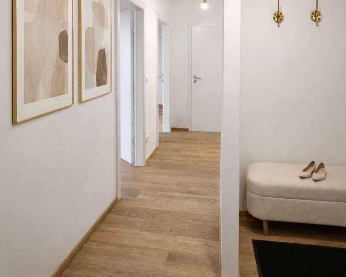 Freundlicher Flur mit Holzboden, moderner Dekoration und Garderobenbereich.