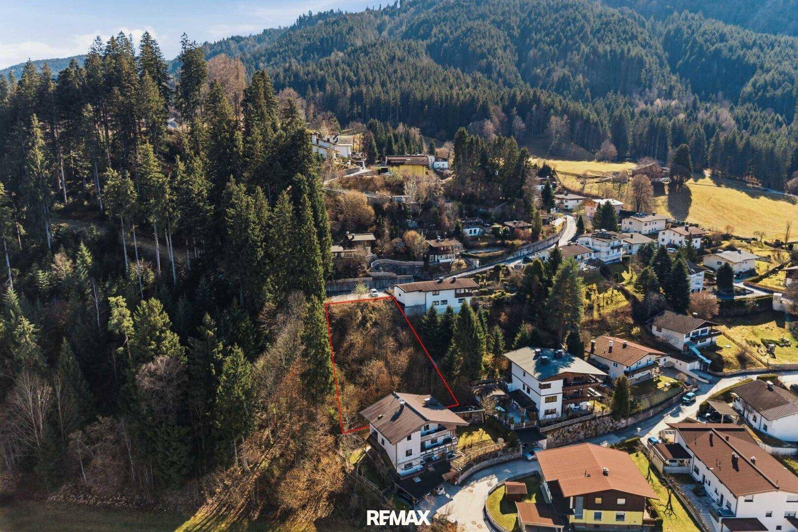Panoramablick auf ein Baugrundstück in einer ländlichen Gegend mit umliegender Bebauung.
