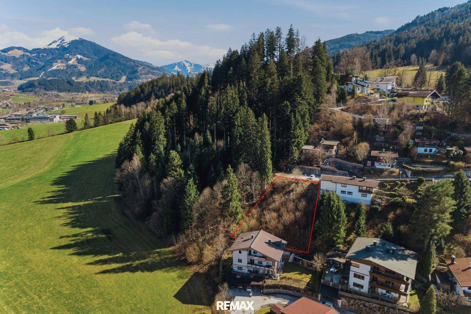 Weitläufige Luftaufnahme eines Grundstücks mit Bergblick und angrenzenden Wiesen.