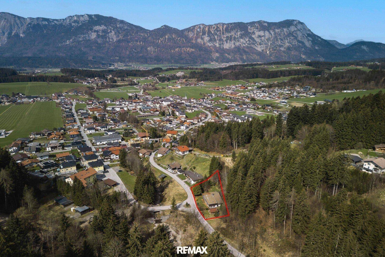 Umfassende Luftaufnahme des Anwesens mit Blick auf ein Dorf und die umliegende Bergkette.