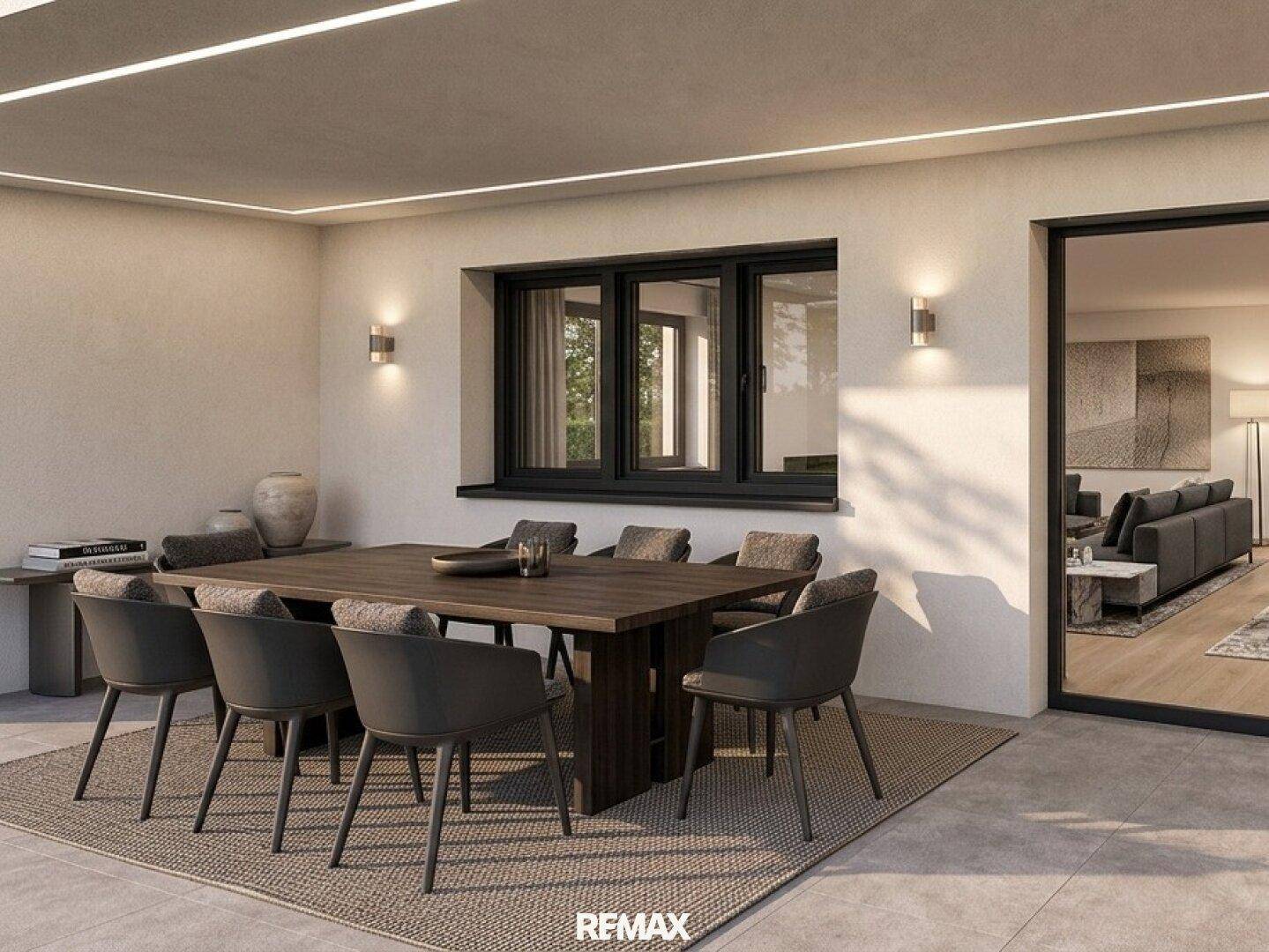 Stilvoller Essbereich im Freien auf einer Terrasse mit großem Holztisch und Blick ins Wohnzimmer.